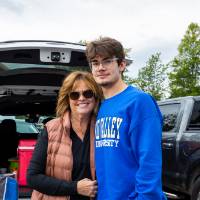 Student and parent pose for photo together during tailgate.